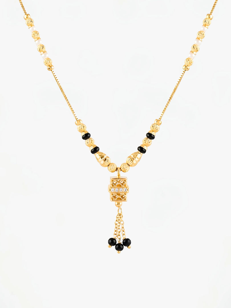 Gold necklace with black beads on a white background
